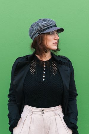 Stylish woman against green wall