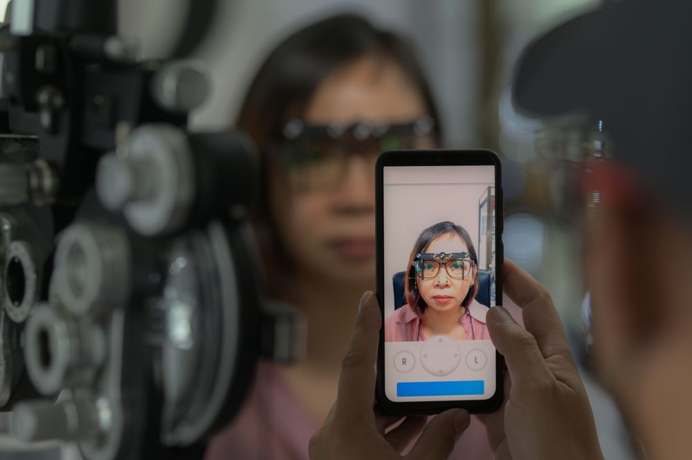 A young woman measures eyesight to make glasses using a smartphone application.