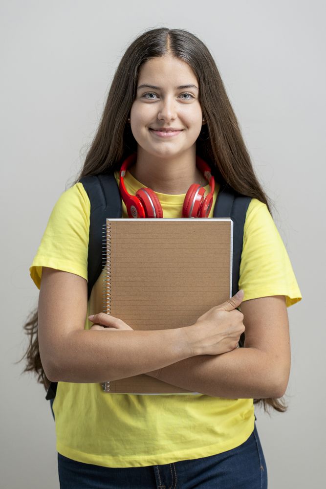 Student life: back to learning with school supplies, teenage girl ready for higher education, holding notebook.