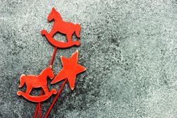 Three red wooden ornaments on grey background
