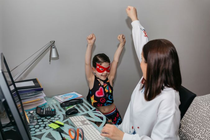 Woman teleworking and playing with her daughter