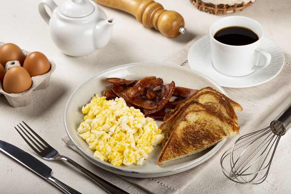 Breakfast with eggs, bacon and toast.