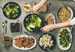 Vegan dinner table setting of healthy vegetarian dishes in plates on table