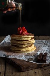 Pancake with strawberries and chocolate covered in syrup
