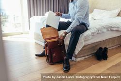 Man sitting on his bed getting ready to go to office bEeKMb