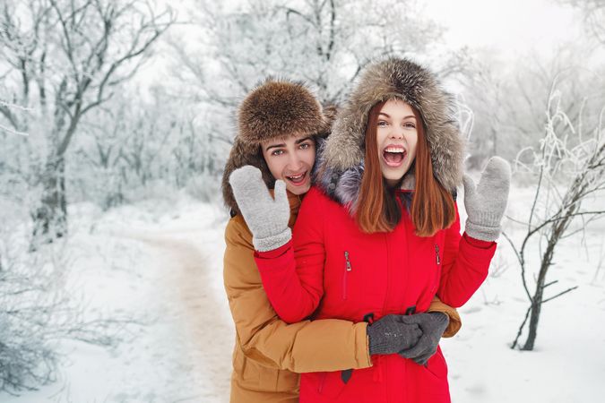 Two young adults on date in the snowy forest