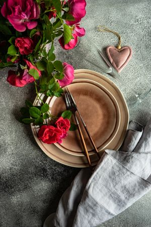 Top view of elegant table setting with roses, champagne flute & heart ornament