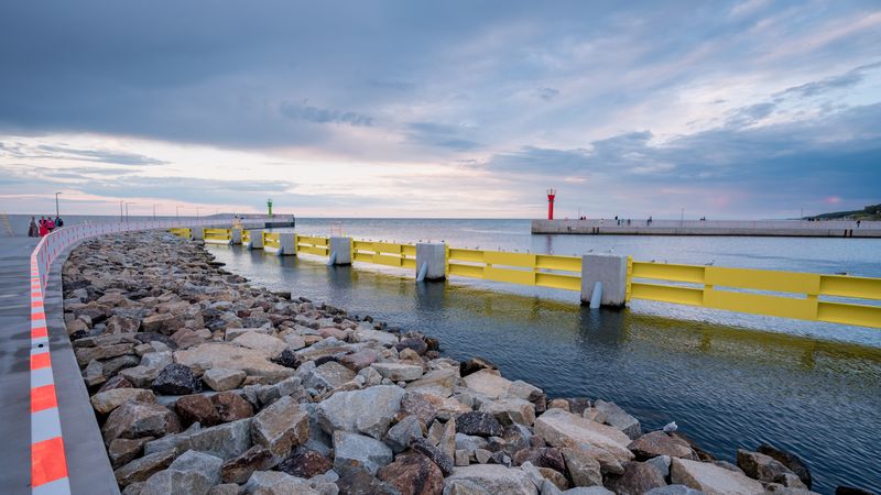 City port with lighthouse with stones in the foreground