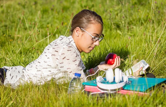 young student reading a book in the park
