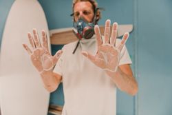 Man in respirator showing hands in dust