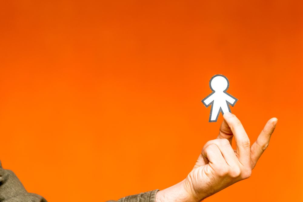 Smiling man holding funny paper toy