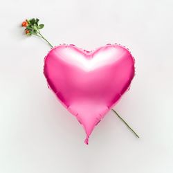 Pink heart balloon with rose on light background