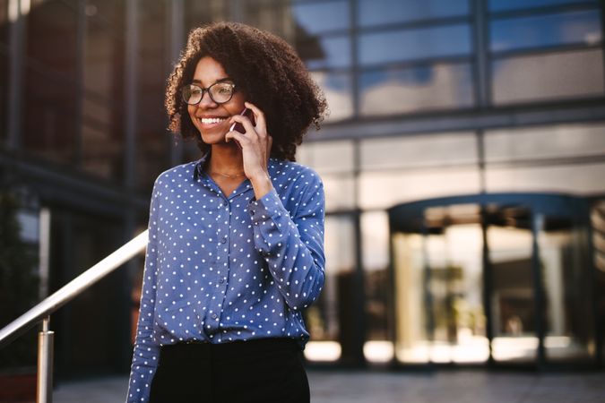 Female business professional walking outside using phone