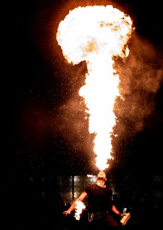 Man blowing fire to the air during nighttime