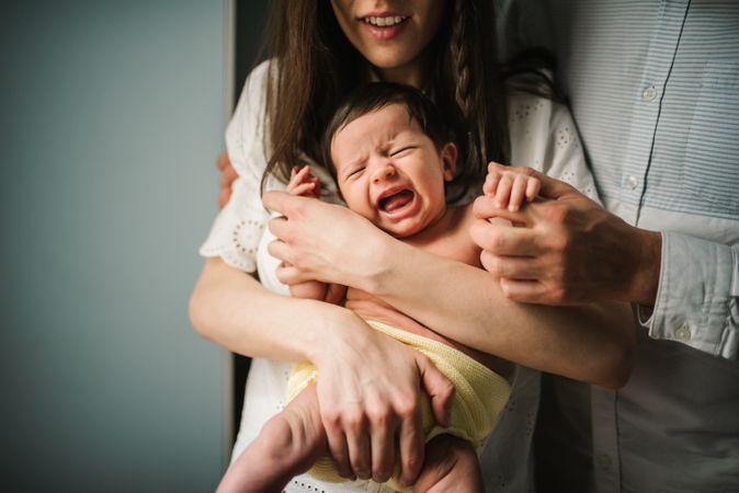 Crop parents comforting crying baby