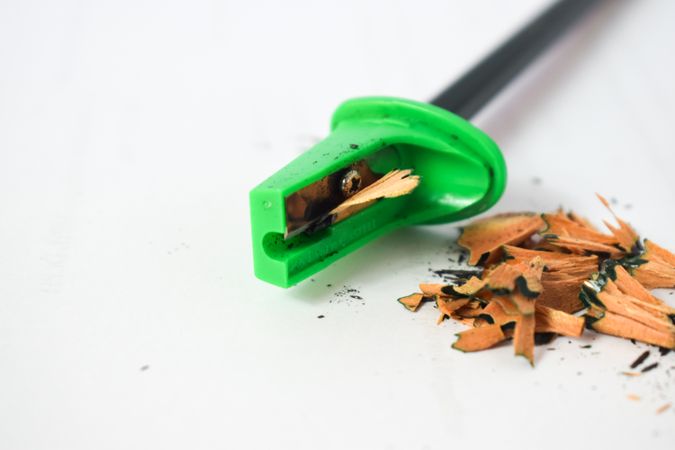 Green pencil sharpener with shavings & copy space