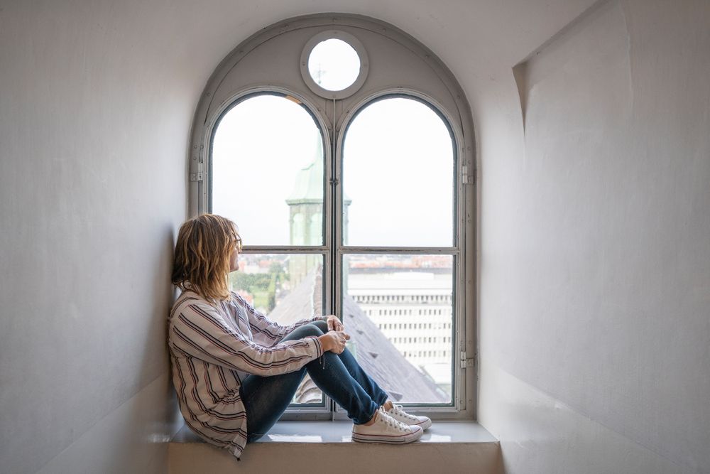 Relaxed woman resting in window sill