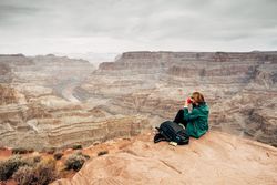 Female relaxing on cliff and admiring picturesque view