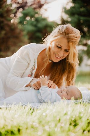 baby with down syndrome lying on a blanket with her grandmother