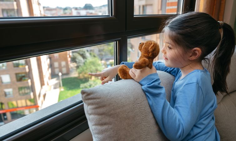 Girl showing the street to her teddy bear