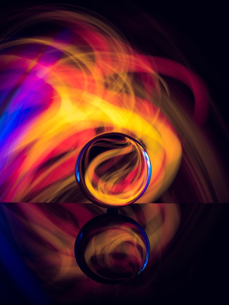 Crystal ball on board near abstract shines