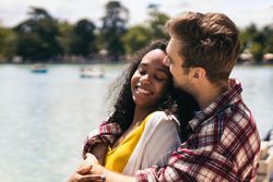 Interracial couple on a romantic date by a beautiful lake