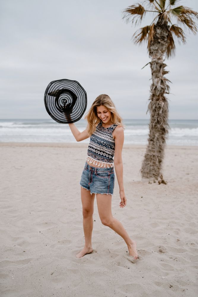 Young female relaxing on beach with hat
