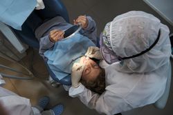 Dentist examining teeth of boy during COVID 19 outbreak