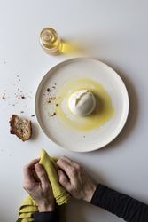 Crop hands with napkin near cheese and condiments