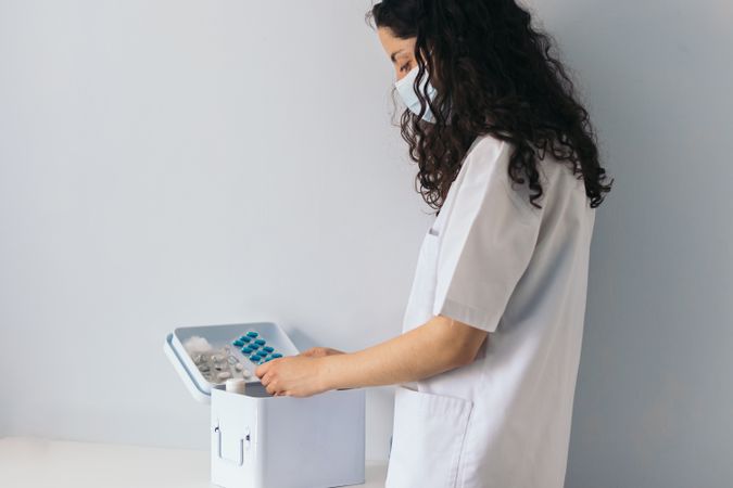 nurse taking medicine from medicine cabinet