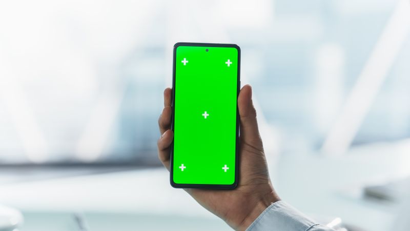 Office Employee Checking Emails on Smartphone with Mock Up Green Screen Chromakey Display. Corporate Workspace Atmosphere. Manager is Connected Online and Working From a Cellphone