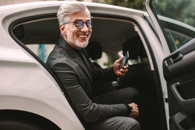Portrait of smiling mature businessman sitting in the backseat of a cab