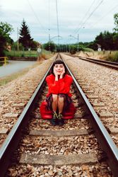 Woman sitting on sleepers in middle of railway