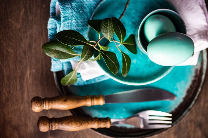 Easter table setting with teal plates and blue decorative eggs