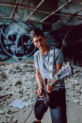 Musician playing electric guitar in abandoned place