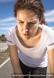 Close up of woman's face as she working out on road 4mALz4