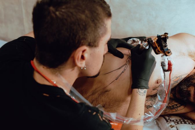 Man getting tattoo on ribs