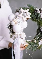 Cropped image of person holding Christmas garland 0gROMb