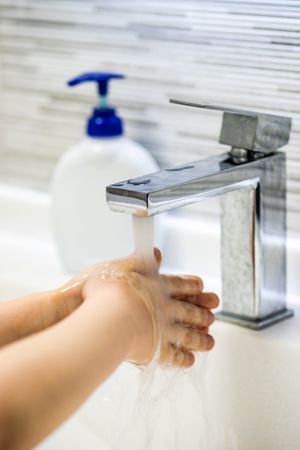 Person washing hands at sink