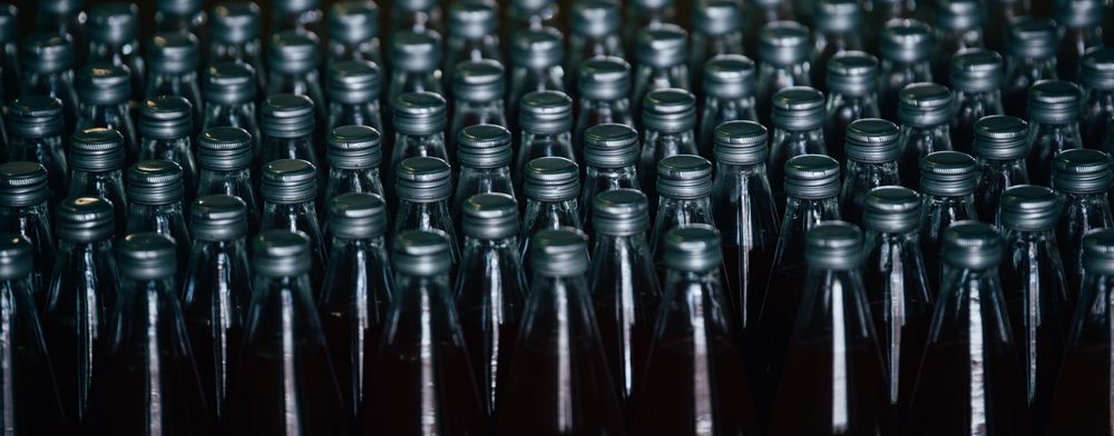 Multiple bottles of fruit juice are arranged in rows