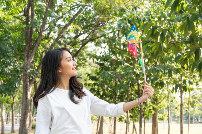 Woman looking at colorful wind toy in park