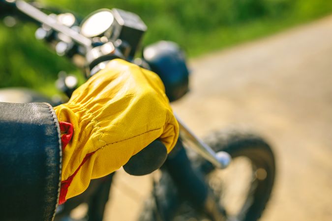 Biker's hand with gloves grabbing the handlebar