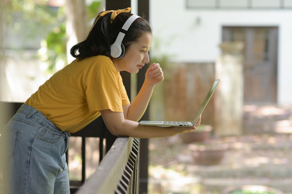 Asian woman uses laptop to work from home.