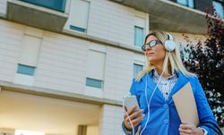 Businesswoman with headphones and mobile