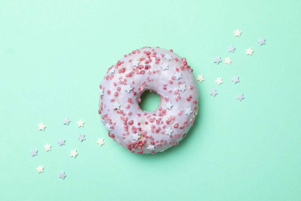 Tasty donut on mint background, top view