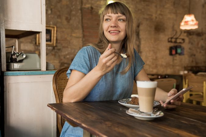 Woman holding spoon with slice of cake