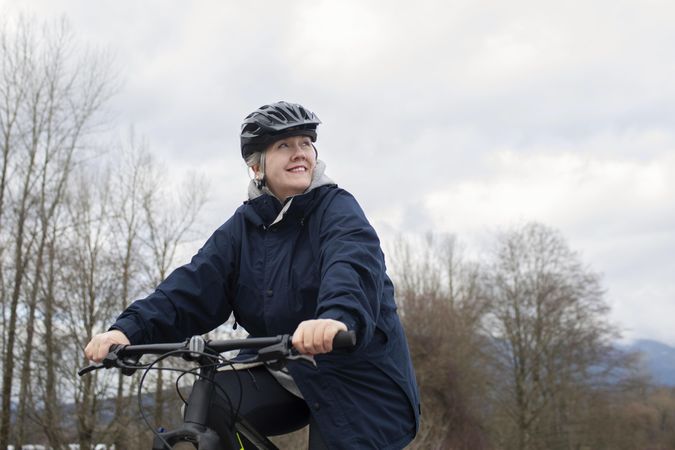 Side view of older woman looking up while riding a bicycle