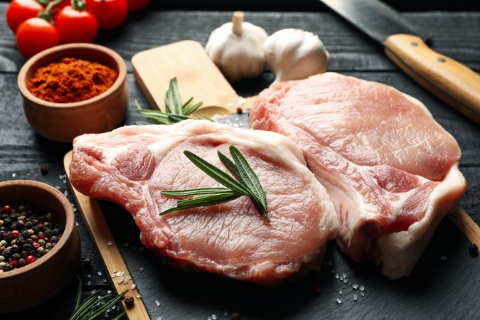 Composition with raw meat for steak and ingredients on wooden background