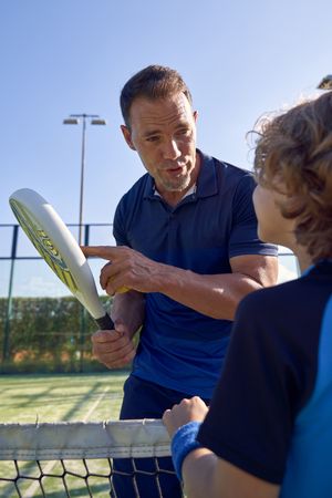 Trainer with boy during padel training