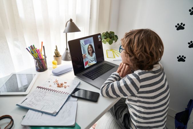 Boy having video call with friend and looking at screen of lapto